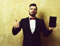 Man of business with beard holds tablet and thumb up