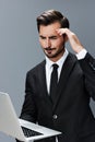 Man business looks into laptop and works thoughtfully online via internet in business suit video call business talks on