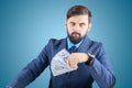 Man in a business suit with banknotes in his hands looks straight, a businessman with a fan of money looks with a tense look Royalty Free Stock Photo