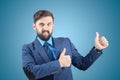 Man in a business suit gives a thumbs-up, and a bearded businessman makes a hand gesture Royalty Free Stock Photo