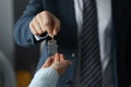 Man in business suit hands overing house keys to woman closeup Royalty Free Stock Photo