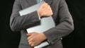 Man in business suit holding laptop computer tight, personal data security