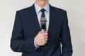 Man in business suit holding a microphone Royalty Free Stock Photo