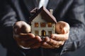 man in business suit holds model of an apartment building in his palms,hands in close-up,concept of mortgage lending, real estate