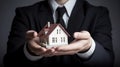 a man in a business suit holds a model of a house in his hands, the concept of real estate and insurance Royalty Free Stock Photo