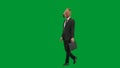 Man in business suit with horse head mask on green studio background. Businessman walking with black suitcase in his Royalty Free Stock Photo
