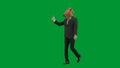 Man in business suit with horse head mask on green studio background. Businessman walking, pointing fingers in the Royalty Free Stock Photo