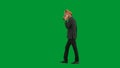 Man in business suit with horse head mask on green studio background. Businessman walking and talking on smartphone Royalty Free Stock Photo