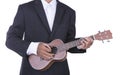 Man in business suit playing ukulele Royalty Free Stock Photo