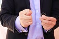 A man in a business suit shows figo, on the other hand shows a wedding ring. The concept of the man does not want to marry