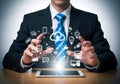 Businessman in suit interacting with digital icons and cloud computing technology with tablet on wooden desk Royalty Free Stock Photo