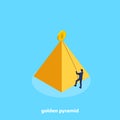 A man in a business suit using a rope tries to climb a golden pyramid Royalty Free Stock Photo