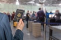 Man businessman in a blue suit holding american passport with boarding pass in the airport opposite customs control or security