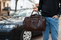 Man businessman with leather bag near a black car Royalty Free Stock Photo
