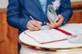 Man businessman signs documents with a pen making the signature sitting at the desk in the light. With retro effect