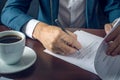 Businessman signs important legal documents on the desktop with Cup of coffee Royalty Free Stock Photo