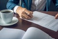 Businessman signs important legal documents on the desktop with Cup of coffee Royalty Free Stock Photo