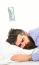 Man, businessman sleeps with banknote above head, white background.