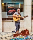 View of Man busker playing guitar on the street of Coimbra, Portugal