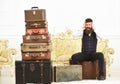 Man, butler with beard and mustache delivers luggage, luxury white interior background. Luggage and relocation concept