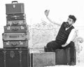 Man, butler with beard and mustache delivers luggage, luxury white interior background. Luggage and travelling concept