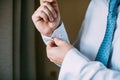 Man buttoning on the sleeve of his shirt. Zip up the cufflink