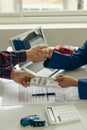 Man buys car and shakes hands with business salesman, closing car sales agreement, gesture and concept of giving keys to new owner Royalty Free Stock Photo