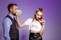 Man with cake on face and brutal girl holding chilli over purple background. Royalty Free Stock Photo