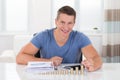 Man Calculating Invoice With Coins At Desk Royalty Free Stock Photo