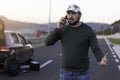 Man calling road assistance on the highway. Calling car service, assistance or  tow truck while having troubles with his car Royalty Free Stock Photo