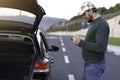 Man calling road assistance on the highway. Calling car service, assistance or  tow truck while having troubles with his car Royalty Free Stock Photo