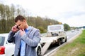 Man calling while tow truck picking up his broken car Royalty Free Stock Photo