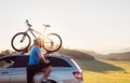 Man came by auto in mountain with his bicycle on the roof. Mount