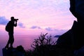 Man with camera climbing rock on the mountain