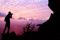 Man with camera climbing rock on the mountain