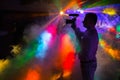 A man with a camera shoots a video at a disco with neon rays Royalty Free Stock Photo