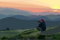 A man with a camera takes pictures of mountains Royalty Free Stock Photo