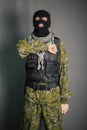 A man in camouflage and bullet proof vest, with a balaclava on his head. A special unit soldier, a modern warrior.