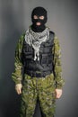 A man in camouflage and bullet proof vest, with a balaclava on his head. A special unit soldier, a modern warrior.