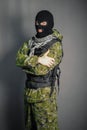 A man in camouflage and bullet proof vest, with a balaclava on his head. A special unit soldier, a modern warrior.