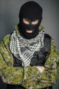 A man in camouflage and bullet proof vest, with a balaclava on his head. A special unit soldier, a modern warrior.