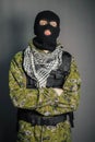 A man in camouflage and bullet proof vest, with a balaclava on his head. A special unit soldier, a modern warrior.
