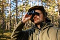 man looking through binoculars in forest. park monitoring, bird watching Royalty Free Stock Photo