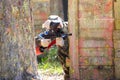 Man in camouflage shooting from paintball gun