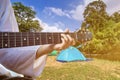 man camping and strum a guitar instrumental music to relax against the background of creek,tent and guitar adventure, travel, Royalty Free Stock Photo