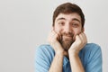 Man can not look away watching cute couple of cats. Portrait of gentle and nice mature bearded guy holding hands on