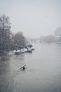 Man in canoe on a snowy Sunday morning on the river Thames