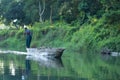 Man canoeing safari on wooden boat Pirogues on the Rapti river, in Chitwan National Park, Nepal Royalty Free Stock Photo