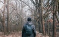 Man in cap and jacket walking through fog forest with backpack. Nature, travel background Royalty Free Stock Photo