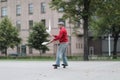 A man in a cap juggles with clubs on the street